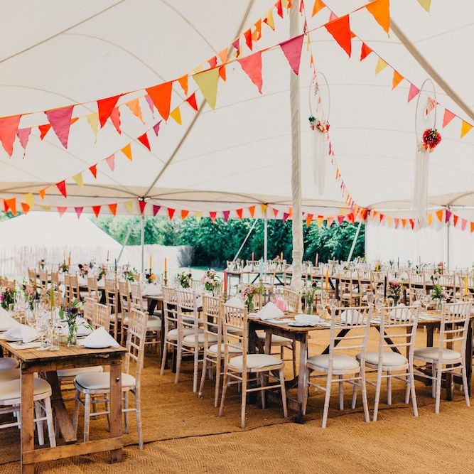 Bright Bunting in Marquee | Dreamcatchers | Colourful Tapered Candles | Wooden Banquet Tables | Wedding Reception Décor | Colourful Bunting Wedding Decor for a Festival Themed Marquee Wedding | Peppermint Love Photography