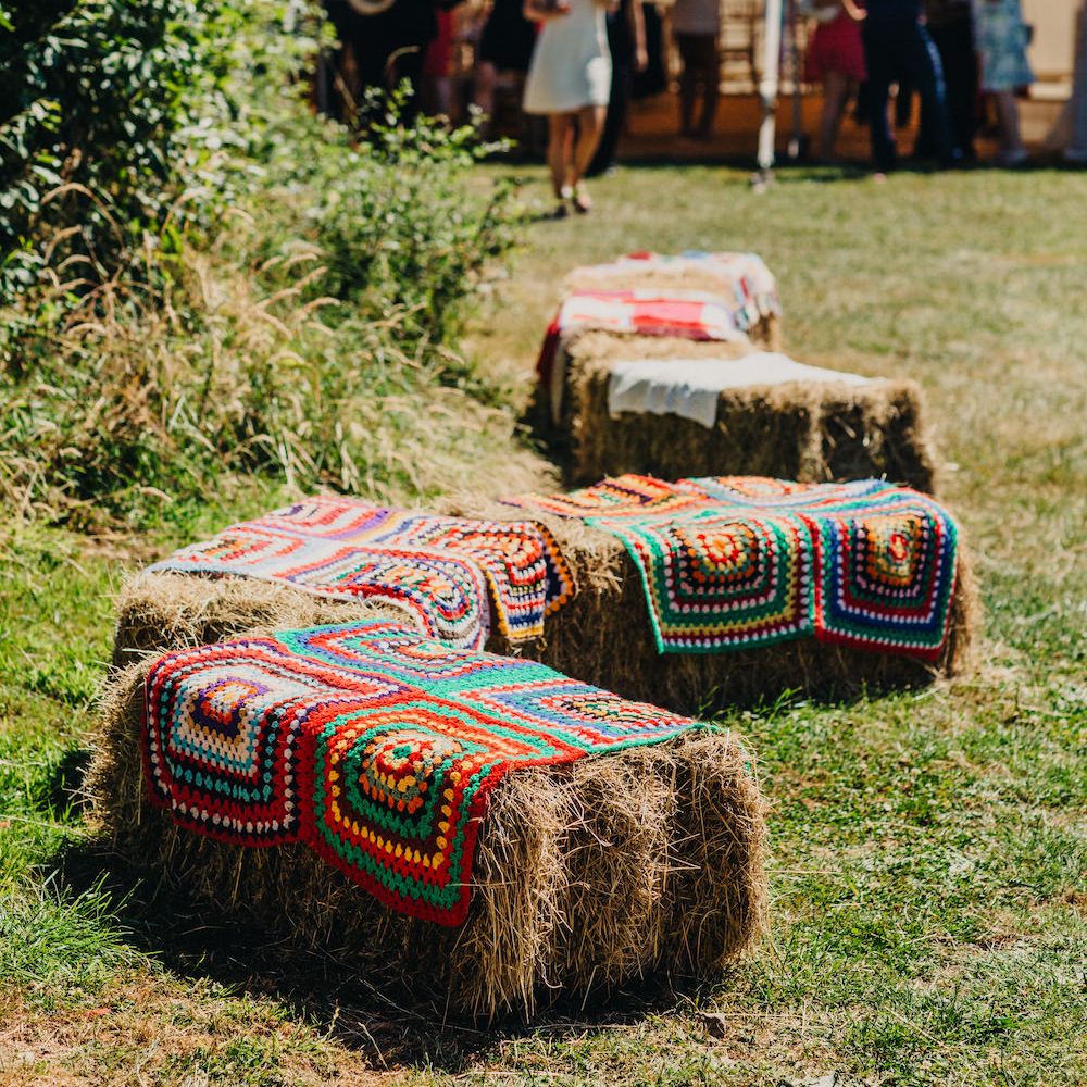 Hay Bales Covered with Colourful Blankets | Colourful Bunting Wedding Decor for a Festival Themed Marquee Wedding | Peppermint Love Photography