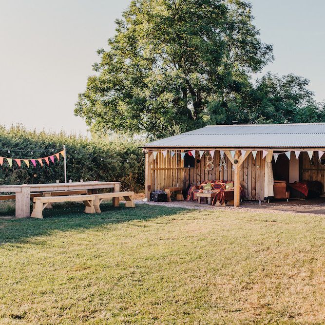 Rustic Bar at Old Summer Dairy | Hay Bales with Colourful Blankets | Colourful Bunting Wedding Decor for a Festival Themed Marquee Wedding | Peppermint Love Photography