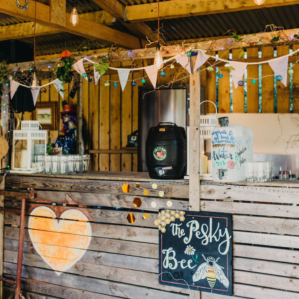 Rustic Bar at Old Summer Dairy | Paper Lanterns | Colourful Fairy Lights | Colourful Bunting Wedding Decor for a Festival Themed Marquee Wedding | Peppermint Love Photography