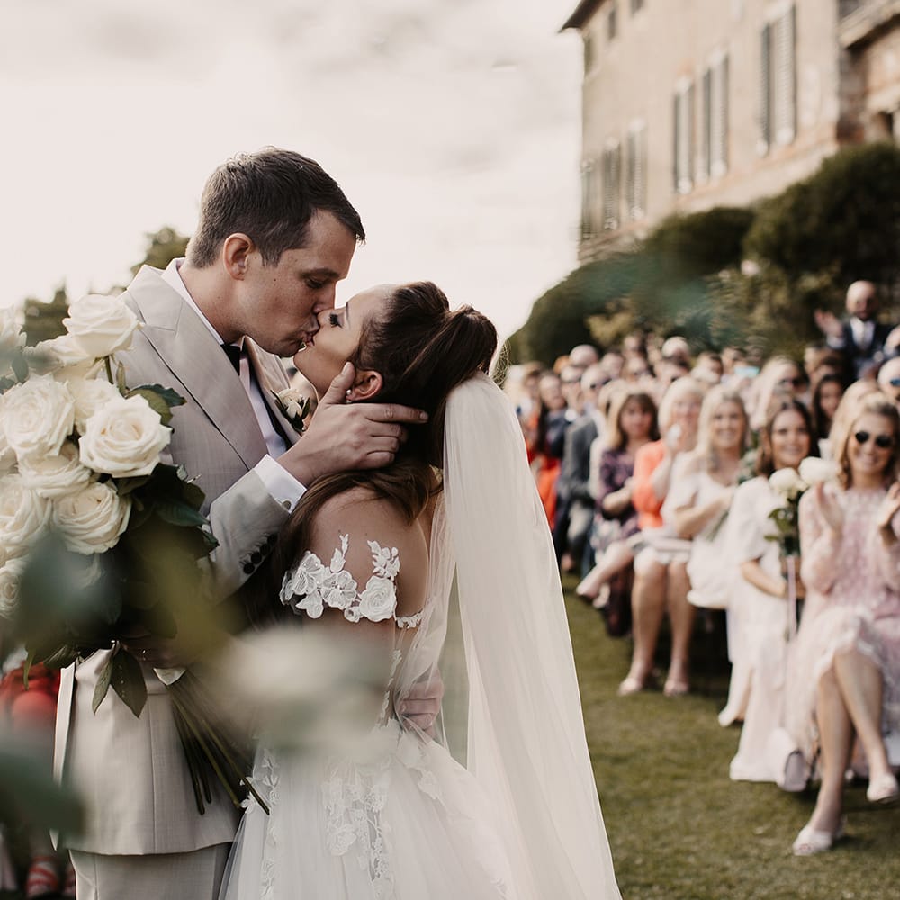 Bride and groom kiss at outdoor ceremony