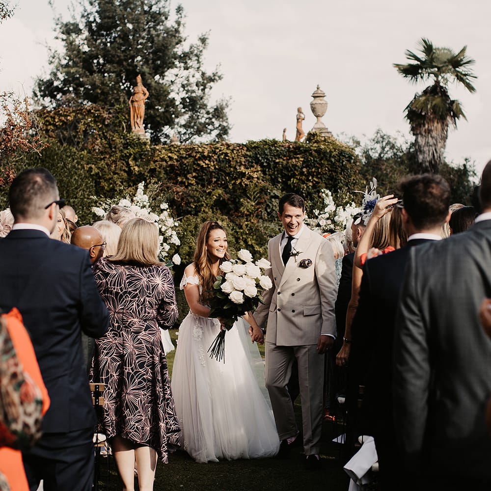 Bride in Galia Lahav dress and groom walk up the aisle