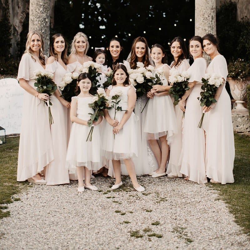 Bridesmaids in blush dresses with white bouquets