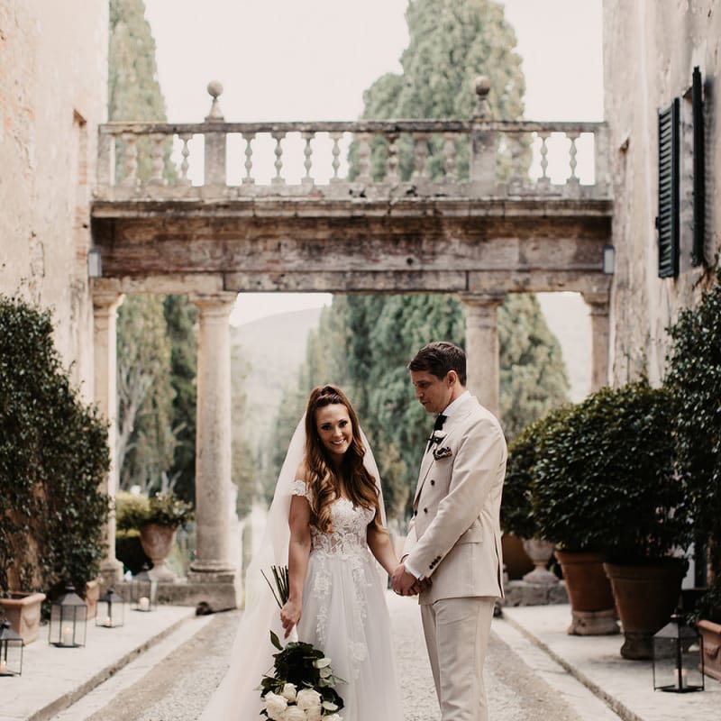 Bride in blush Galia Lahav wedding dress with groom in cream wedding suit