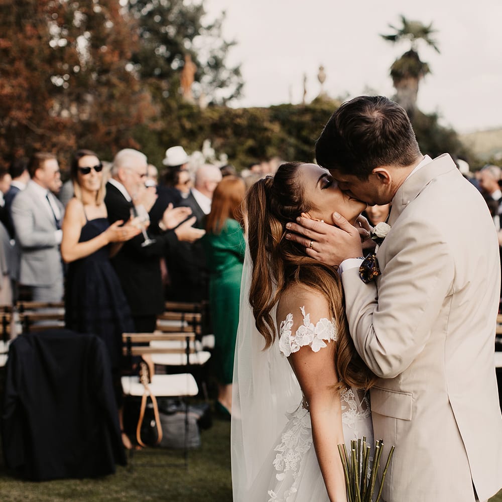 Bride in Galia Lahav wedding dress kisses groom
