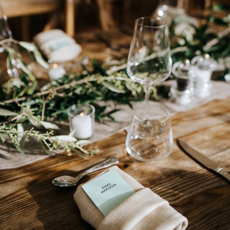 Close-up of placecard and decoration on wooden table to be used for wedding breakfast