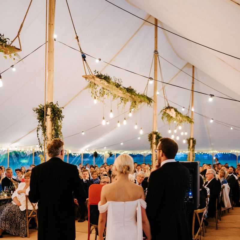 Father of the bride delivering his speech as guests listen attentively inside marquee at Hawarden Castle, Wales