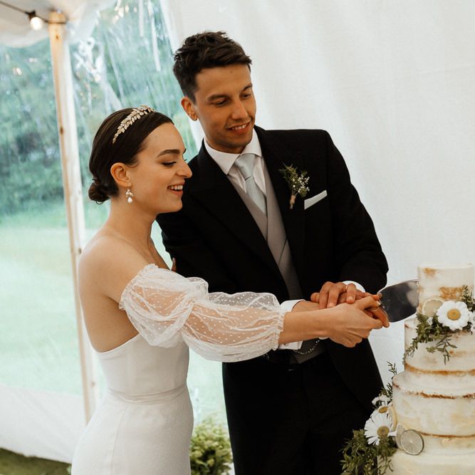 Bride In Strapless Wedding Dress Cuts Cake With Groom
