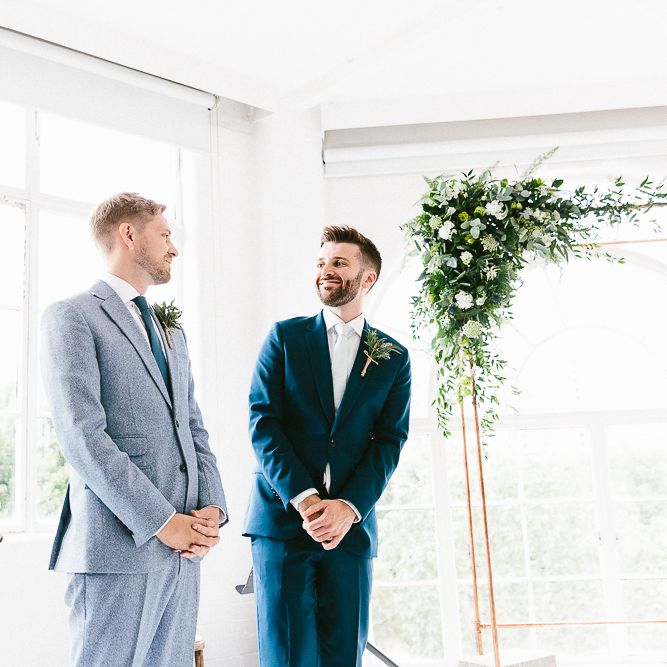 Wedding Ceremony | Groom in Dark Petrol Blue Suit by Paul Smith | Groom in Light Blue Made To Measure Suit by Beggars Run | Copper Arch with White Flowers and Foliage | Same Sex Wedding with Industrial Styling at Wimborne House | Marmelo Photography