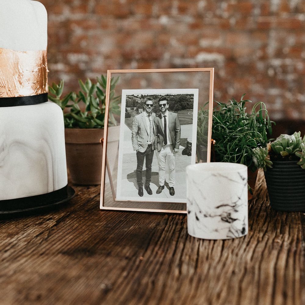 Wedding Reception Decor | Marble Wedding Cake with Copper Leaf | Photo in Copper Frame | Potted Plants | Succulents | Same Sex Wedding with Industrial Styling at Wimborne House | Marmelo Photography