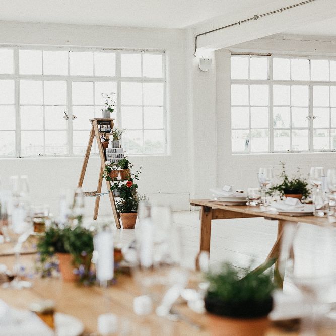 Wedding Reception Decor | Trestle Tables | Huge Warehouse Windows | Whitewashed Walls | Industrial Ladder with Potted Plants | Same Sex Wedding with Industrial Styling at Wimborne House | Marmelo Photography