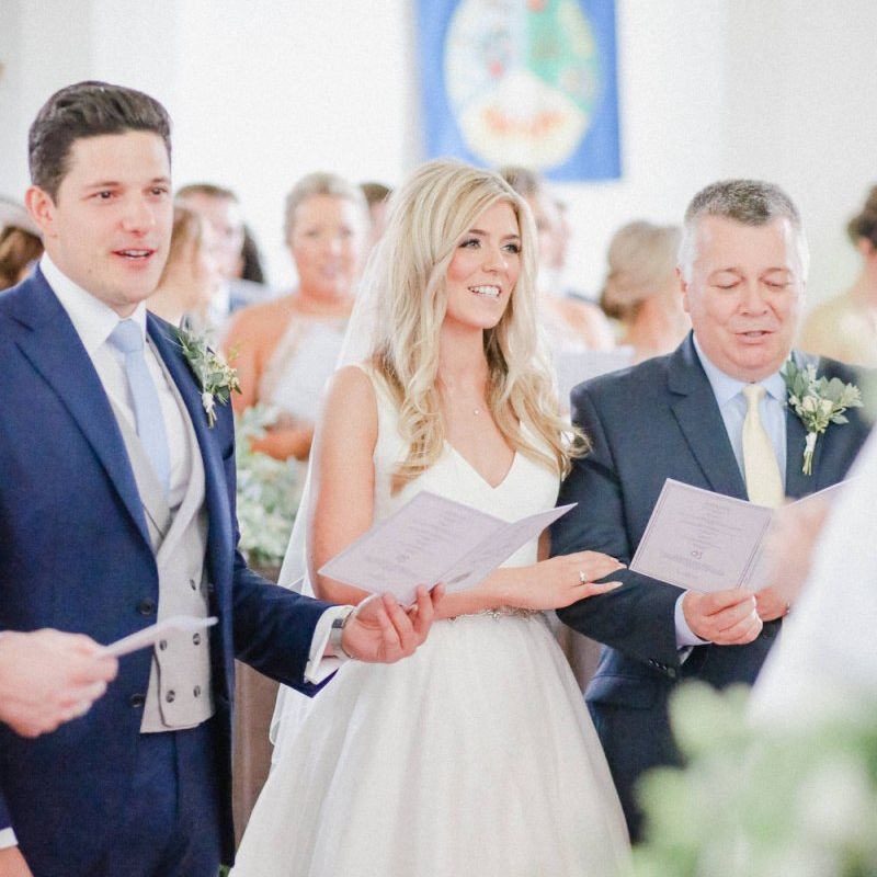 Bride and groom at the church altar singing hymns