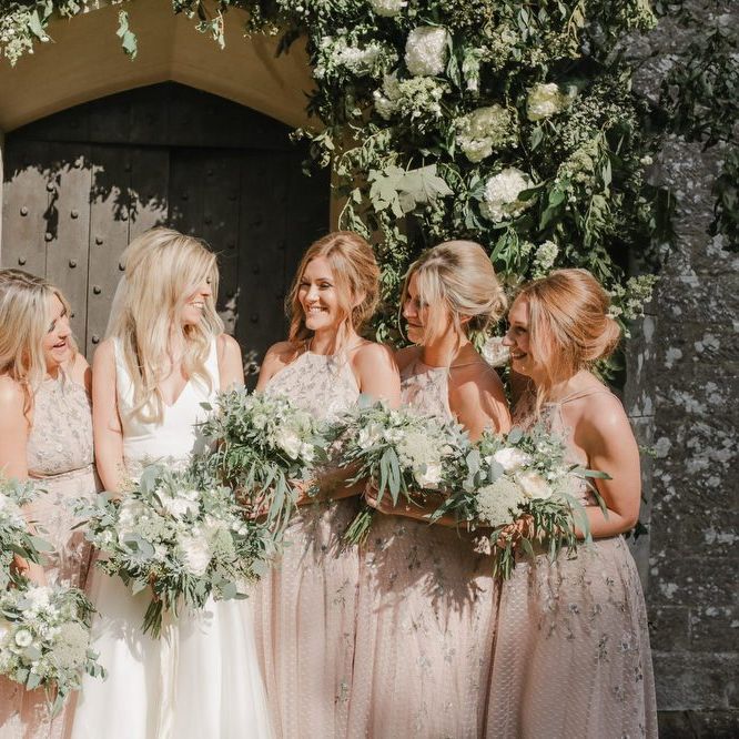Bridal party portrait outside the church under a floral arch