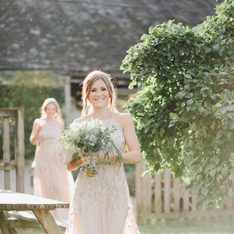 Bridesmaid in pink halter neck dress with embroidery detail