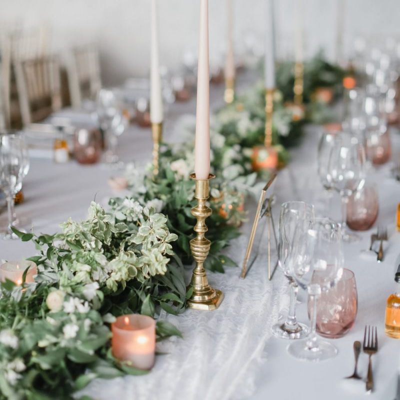 Foliage table runner and coloured taper candles at Askham Hall reception
