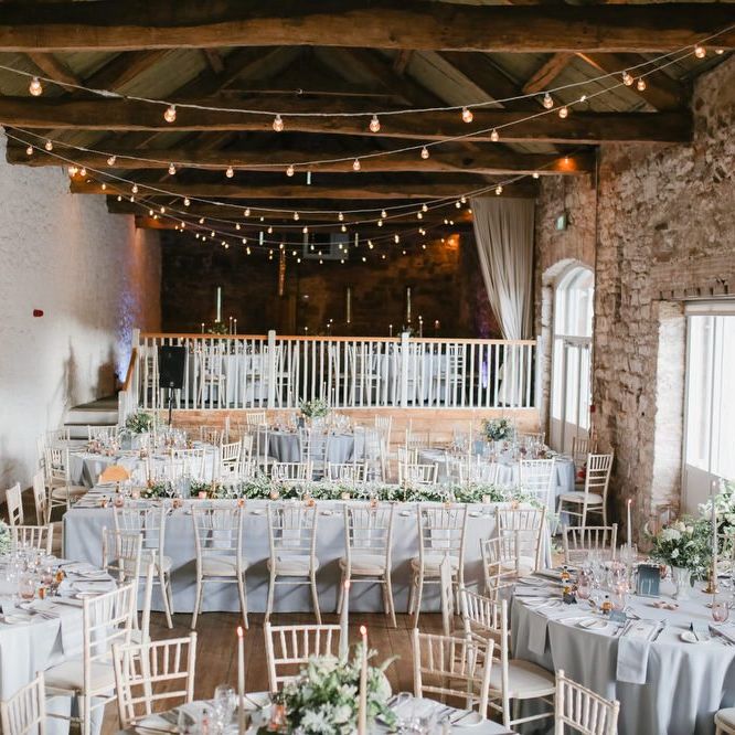 Askham Hall wedding reception with fairy lights, taper candles and foliage