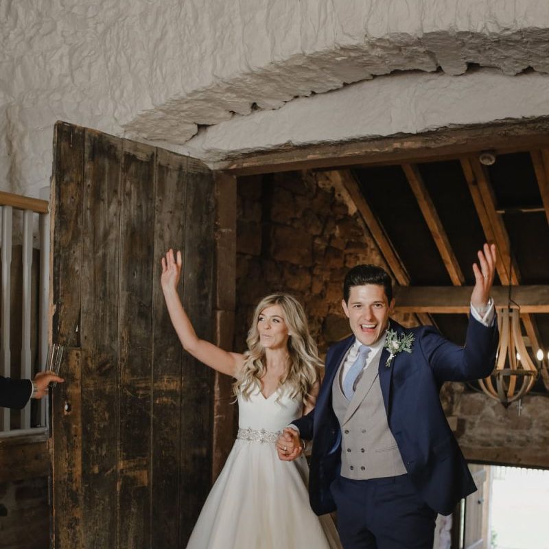 Bride and groom entering their Askham Hall wedding reception