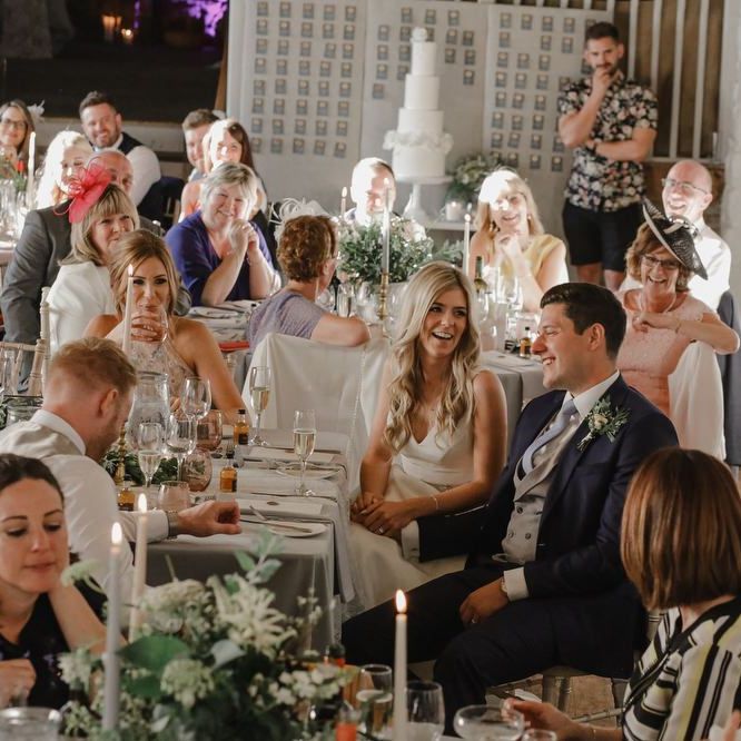 Bride and groom laughing and holding hands during Askham Hall reception