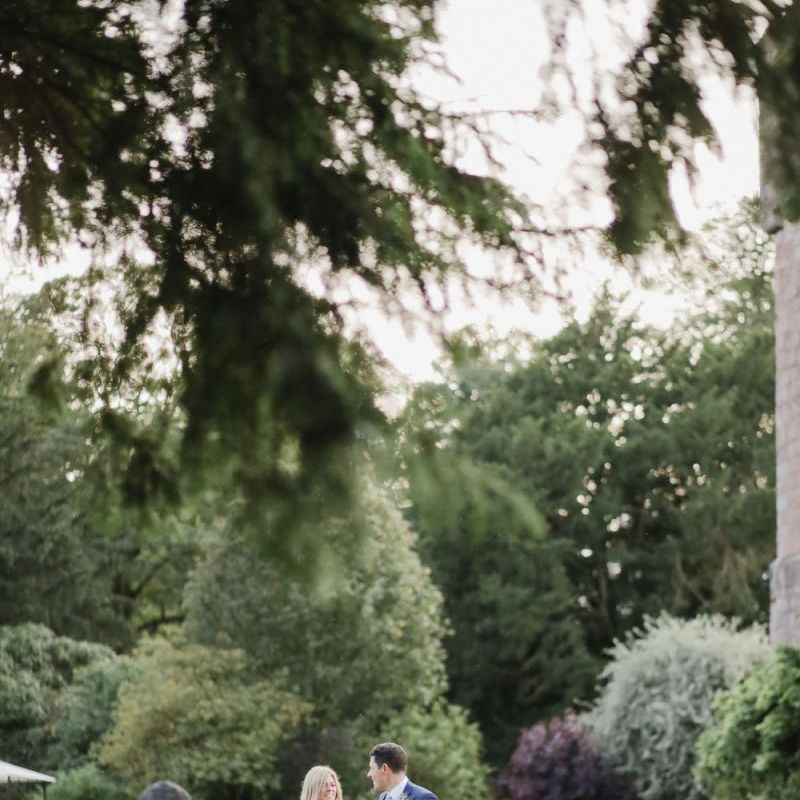 Bride and groom walking through Askham Hall gardens