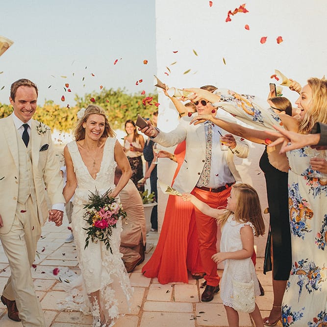 Confetti Moment | Bride in Custom Clemence Halfpenny London Bridal Gown | Groom in Cream Three Piece Suit | Brightly Coloured Destination Wedding at Masseria Potenti Wedding Venue, Puglia, South Italy | Petar Jurica Photography | Marco Odorino Film