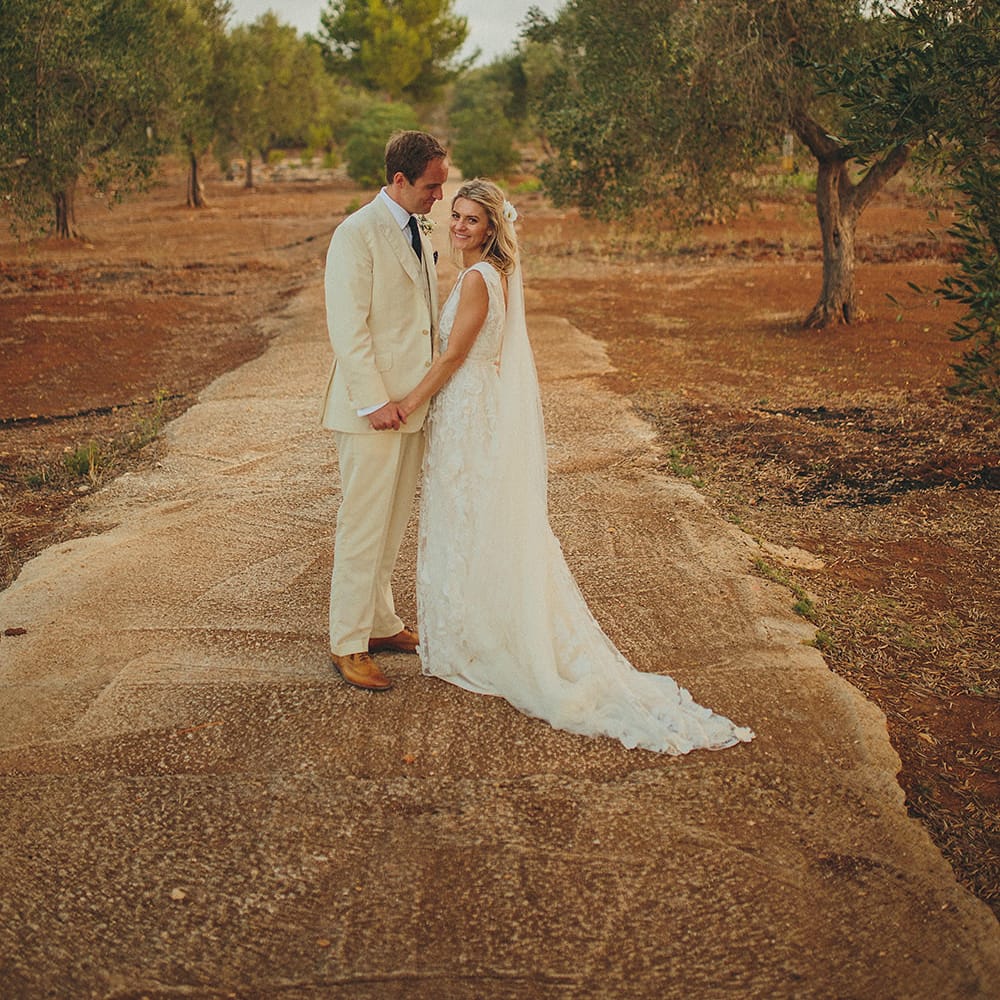 Bride in Custom Clemence Halfpenny London Bridal Gown | Groom in Cream Three Piece Suit | Brightly Coloured Destination Wedding at Masseria Potenti Wedding Venue, Puglia, South Italy | Petar Jurica Photography | Marco Odorino Film