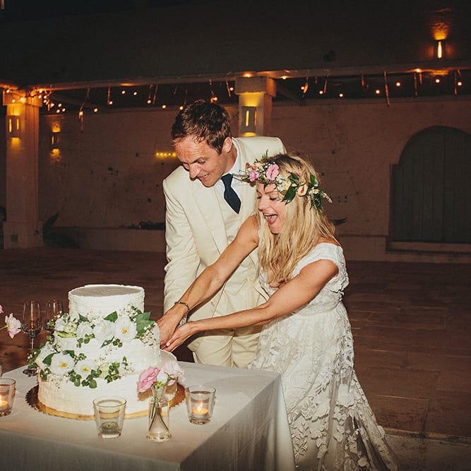 Cutting the Cake | Bride in Custom Clemence Halfpenny London Bridal Gown | Groom in Cream Three Piece Suit | Brightly Coloured Destination Wedding at Masseria Potenti Wedding Venue, Puglia, South Italy | Petar Jurica Photography | Marco Odorino Film