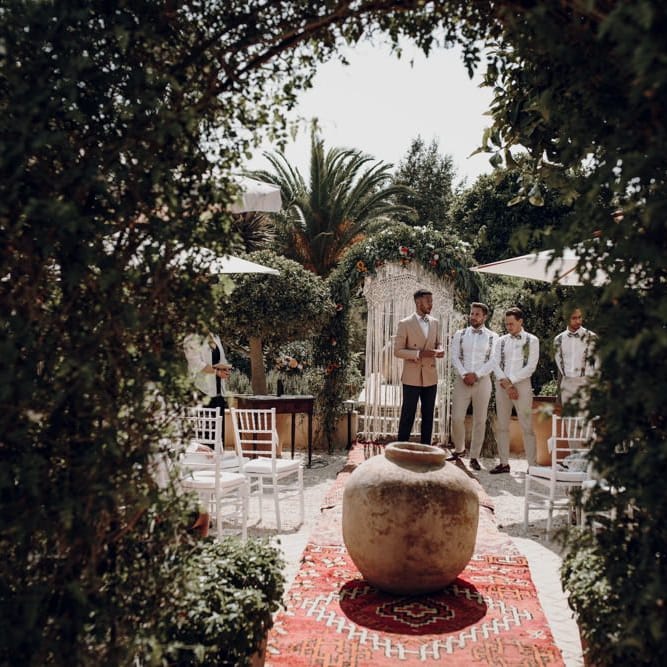 Groom in salmon blazer waiting at the altar for his bride