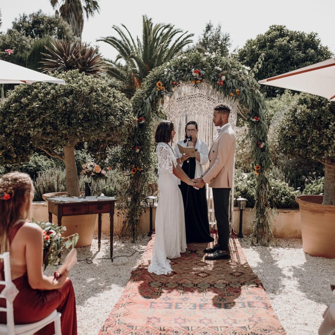 Bride and groom exchanging vows at destination wedding with bride in Grace Loves Lace dress