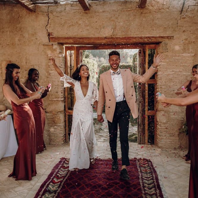 Bride in Grace Loves Lace dress and groom entering the wedding breakfast flanked by the bridesmaids