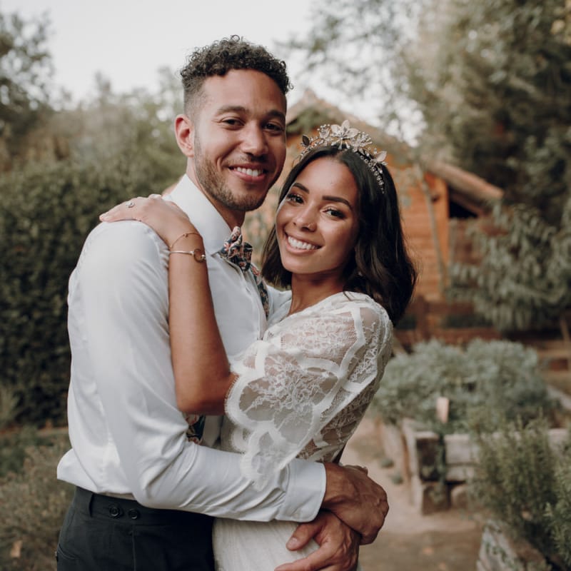 Boho bride and groom embracing with bride in Tilly Thomas Lux crown