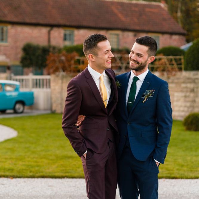 Grooms in Burgundy and Navy Remus Uomo Suits Embracing Outside Hazel Gap Barn