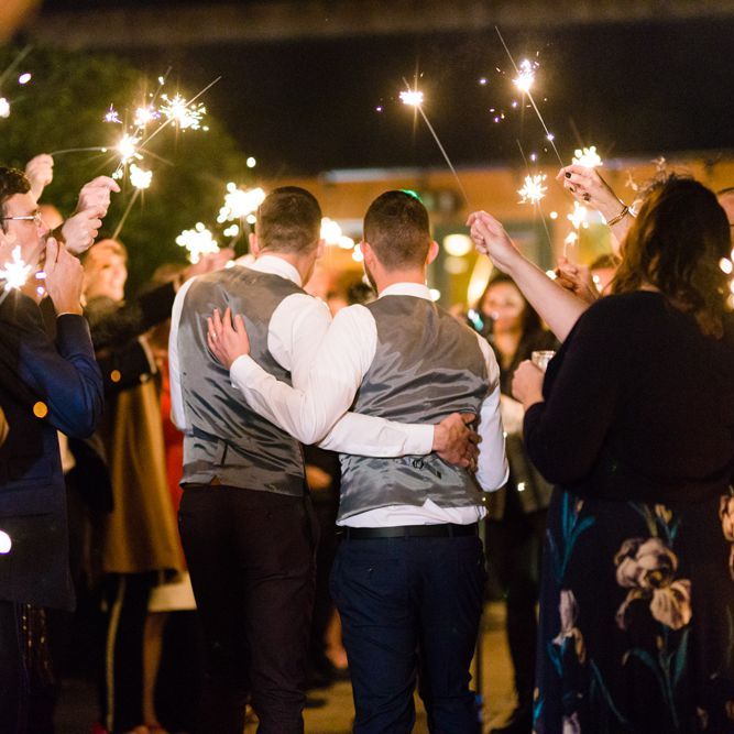 Sparkler Moment with Two Grooms in Burgundy and Navy Remus Uomo Suits