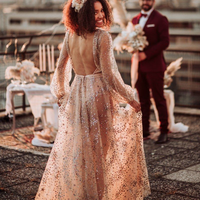 Bride in backless sparkle wedding dress with flowers in her hair