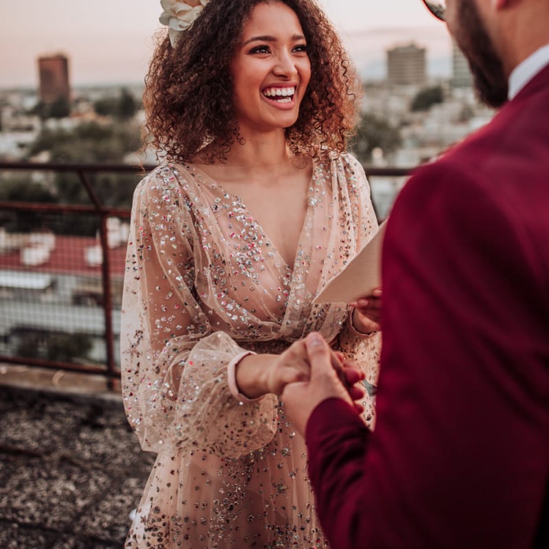 Bride in sparkle wedding dress with curly hair and flowers