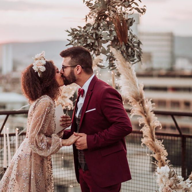 Bride and groom kissing at rooftop wedding