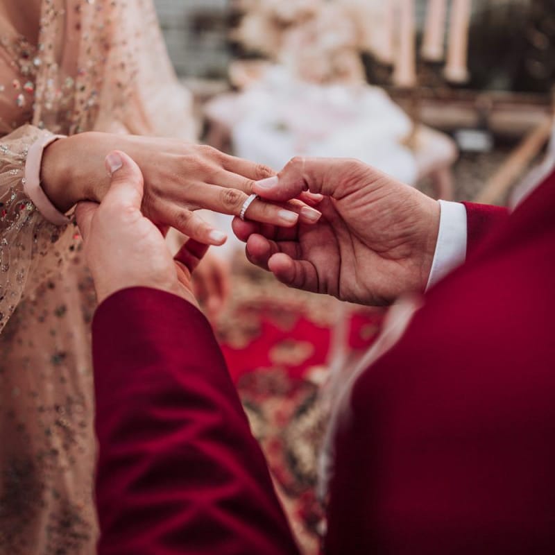 Groom putting on his brides engagement wedding ring
