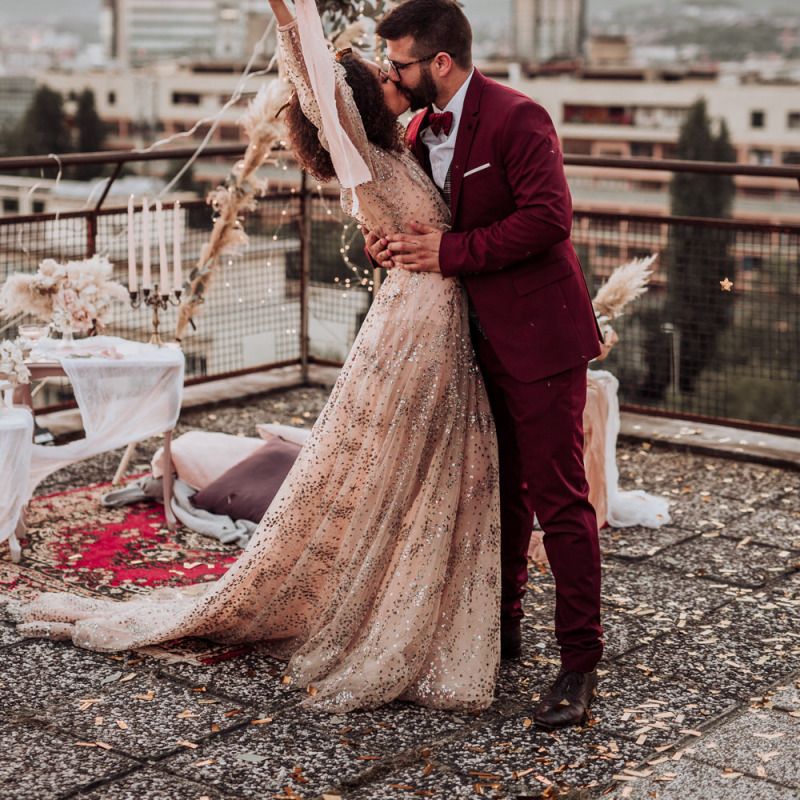 Boho bride and groom celebrating at intimate rooftop wedding