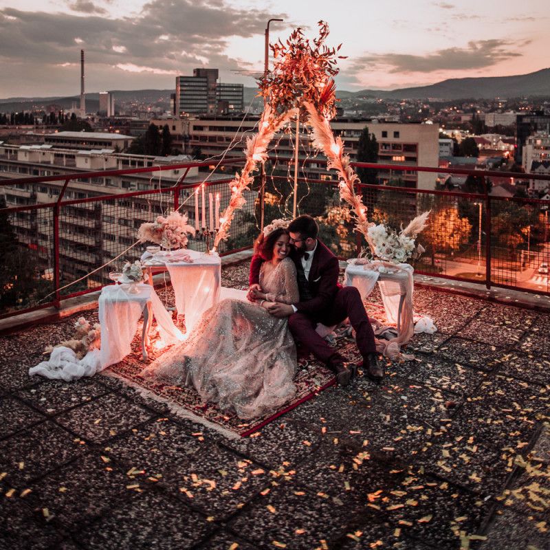 Intimate rooftop wedding celebration with fairy light covered tipi structure