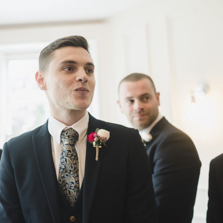 Groom in blue wedding suit and patterned tie