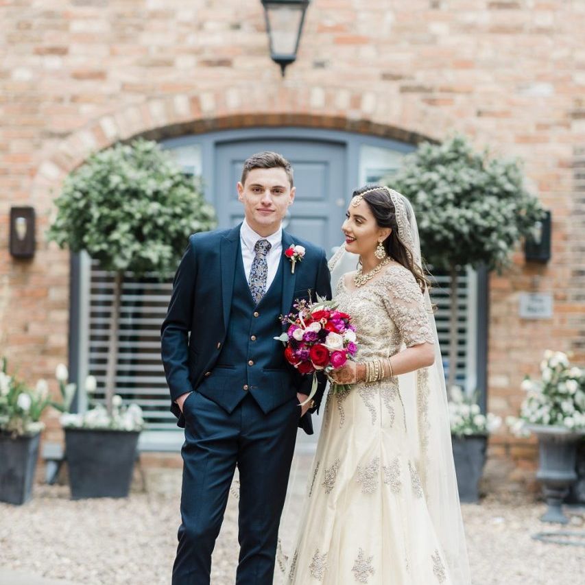 Bride and groom at multicultural wedding with red bridesmaid dresses