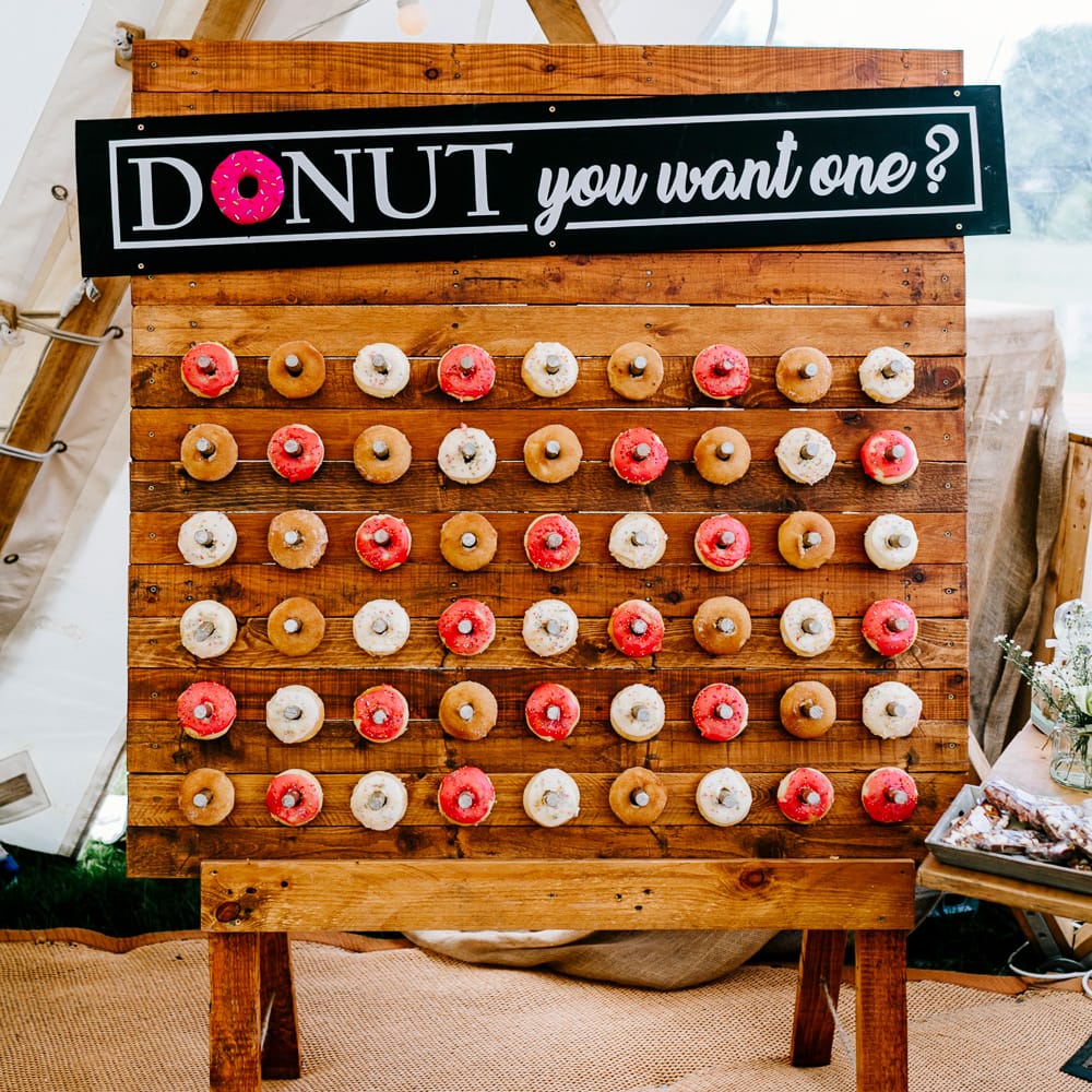 Donut Wall For Wedding // Bride In Floral Dress By Stephanie Allin Festival Wedding With Food Trucks &amp; Outdoor Ceremony With Geo Dome Tent Baya Hire Epic Love Story Photography