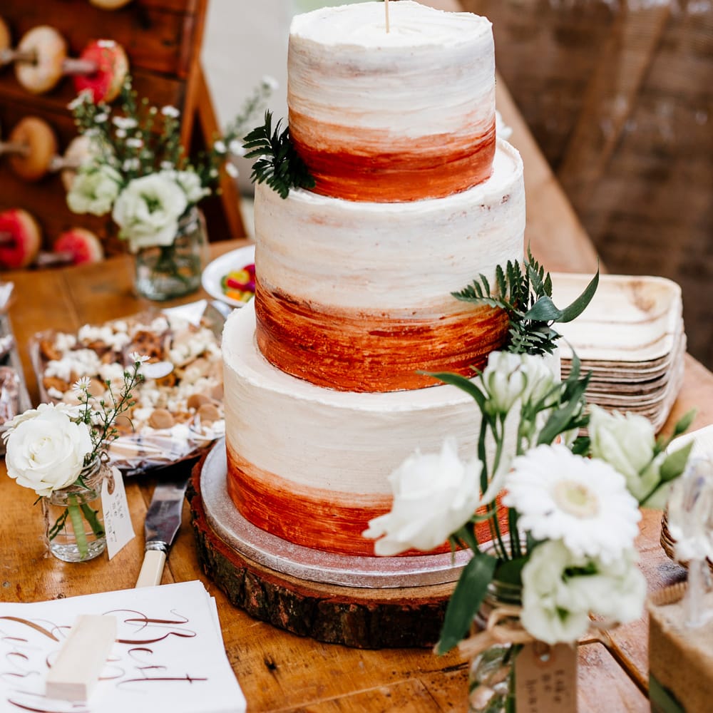 Bronze &amp; White Wedding Cake With Cake Topper // Bride In Floral Dress By Stephanie Allin Festival Wedding With Food Trucks &amp; Outdoor Ceremony With Geo Dome Tent Baya Hire Epic Love Story Photography