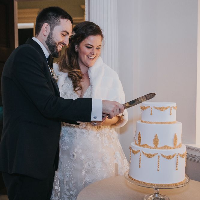 Bride and Groom Cut The Cake with Gold Detail
