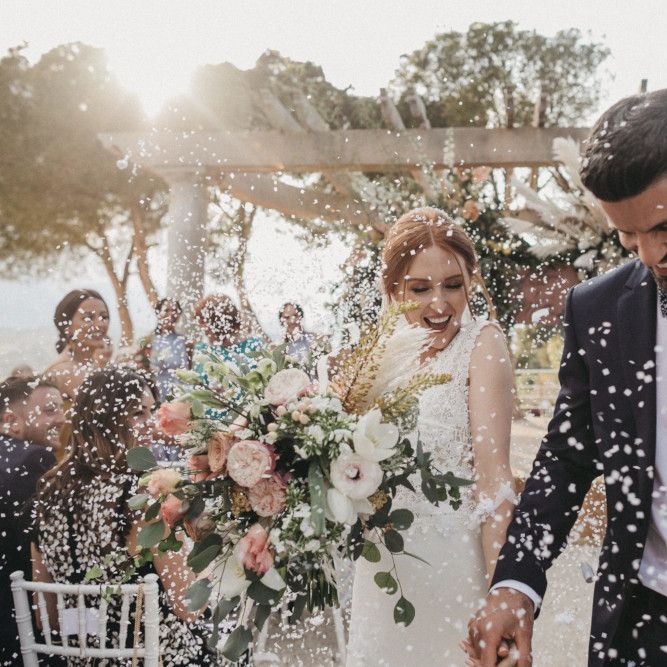 Confetti Moment with Groom in Tuxedo and Bride in Pronovias Wedding Dress