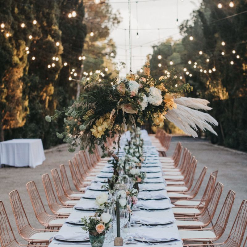 Long Wedding Reception Table with Peach Flowers, Pampas Grass Installation and Festoon Lights