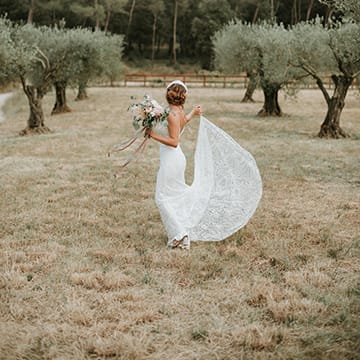 Bride In Low Back Lace Dress With Feather Headdress With Peony Bouquet