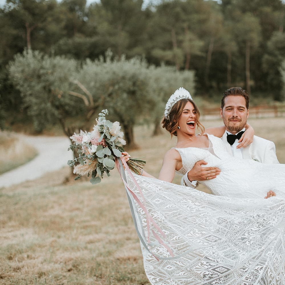 Groom Lifts Bride In Lace Dress With Feather Headdress