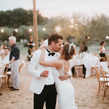 Bride and Groom Steal A Kiss During Outdoor Reception
