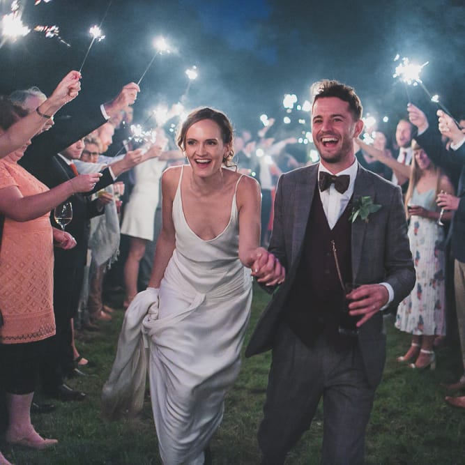 Sparklers At Wedding // Rainy Festival Wedding In East Sussex With Bride In Rime Arodaky And Black Biker Boots And Bridesmaids In White Dresses With Silent Disco Party Images By Jesus Caballero