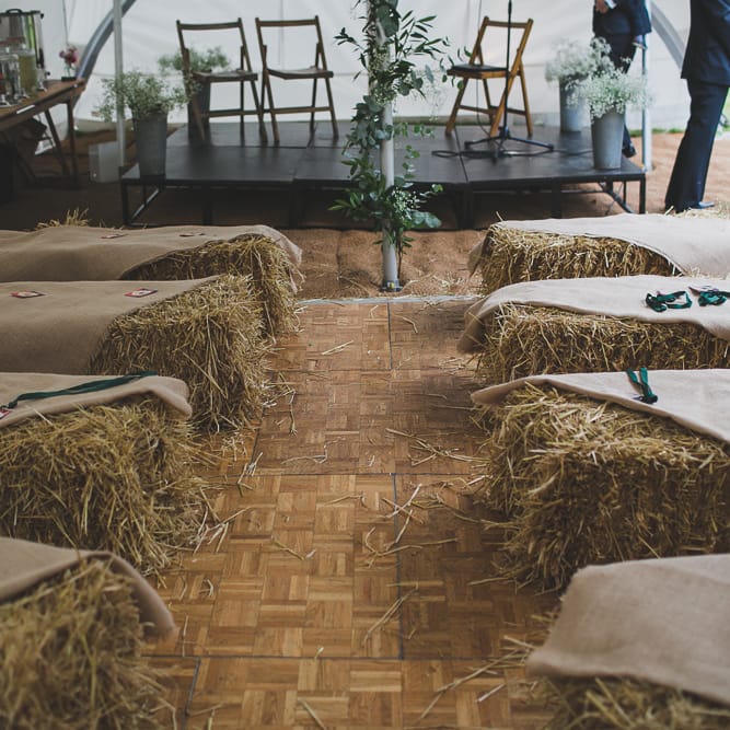 Haybale Seating For Wedding Ceremony // Rainy Festival Wedding In East Sussex With Bride In Rime Arodaky And Black Biker Boots And Bridesmaids In White Dresses With Silent Disco Party Images By Jesus Caballero
